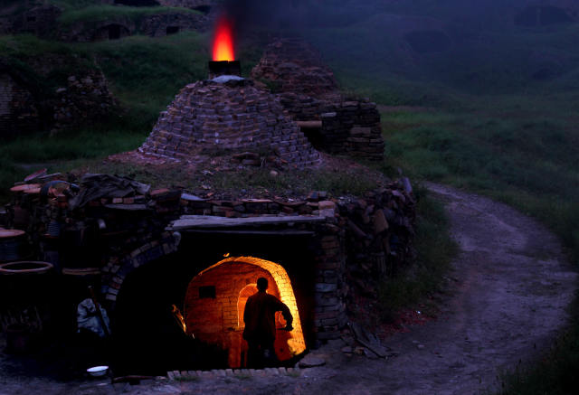 陶瓷要烧成时,窑匠要加大用煤量,烟道口出现通红的火焰(6月9日摄).