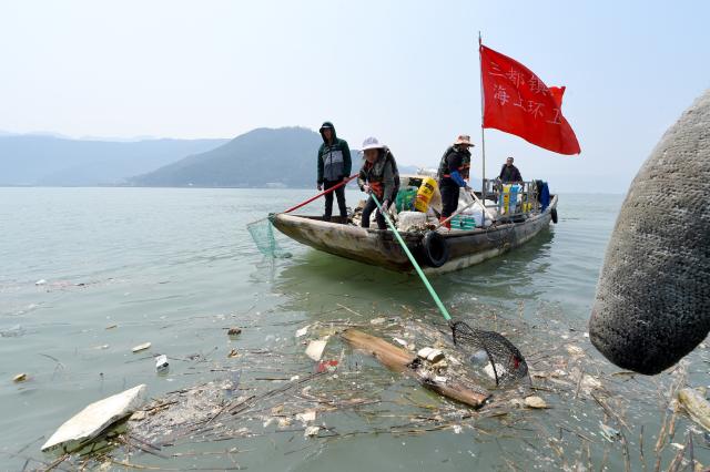 福建省宁德市三都镇海上环卫所的环卫工人在清理海面漂浮物(3月27日