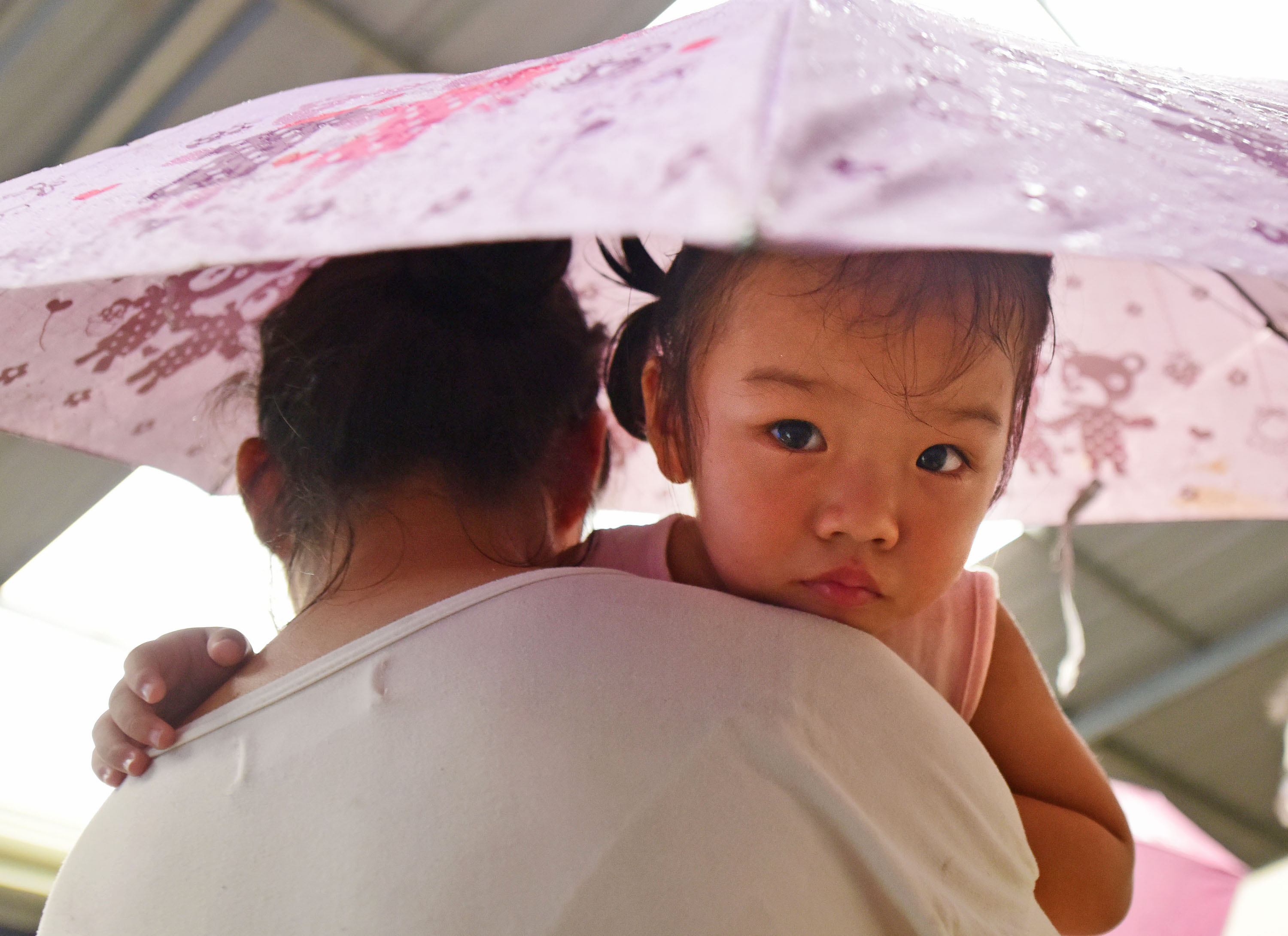7月13日，牛山湖渔场职工江红带着女儿准备撤离。新华社记者 程敏 摄