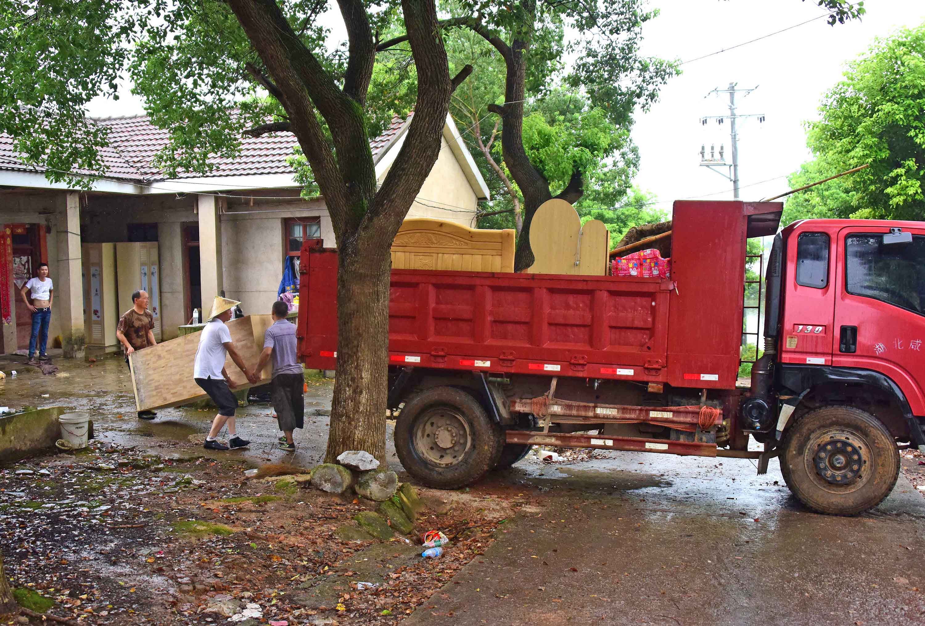 渔场工人在往卡车上搬家具。新华社记者 程敏 摄