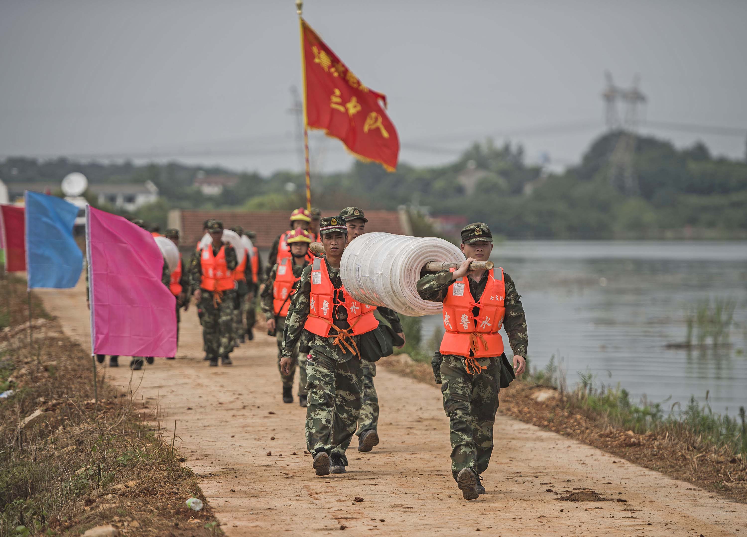 7月13日，武警水电第七支队的战士在牛山湖坝上进行破垸前的准备施工作业。新华社记 者肖艺九摄