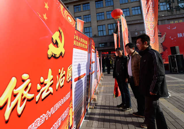 2014年12月4日，西安市民在宪法日宣传活动现场观看依法治国宣传展板。新华社记者 李一博