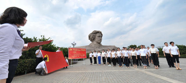 2015年6月30日，长沙市岳麓区新发展的预备党员、入党积极分子站在橘子洲景区毛泽东青年艺术雕塑头像前宣誓。新华社记者 龙弘涛