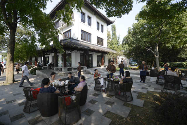 2014年10月4日，游客在杭州西湖边的“隐轩”喝茶。“隐轩”由原高档会所“涌金楼”转型而来。新华社记者 韩传号