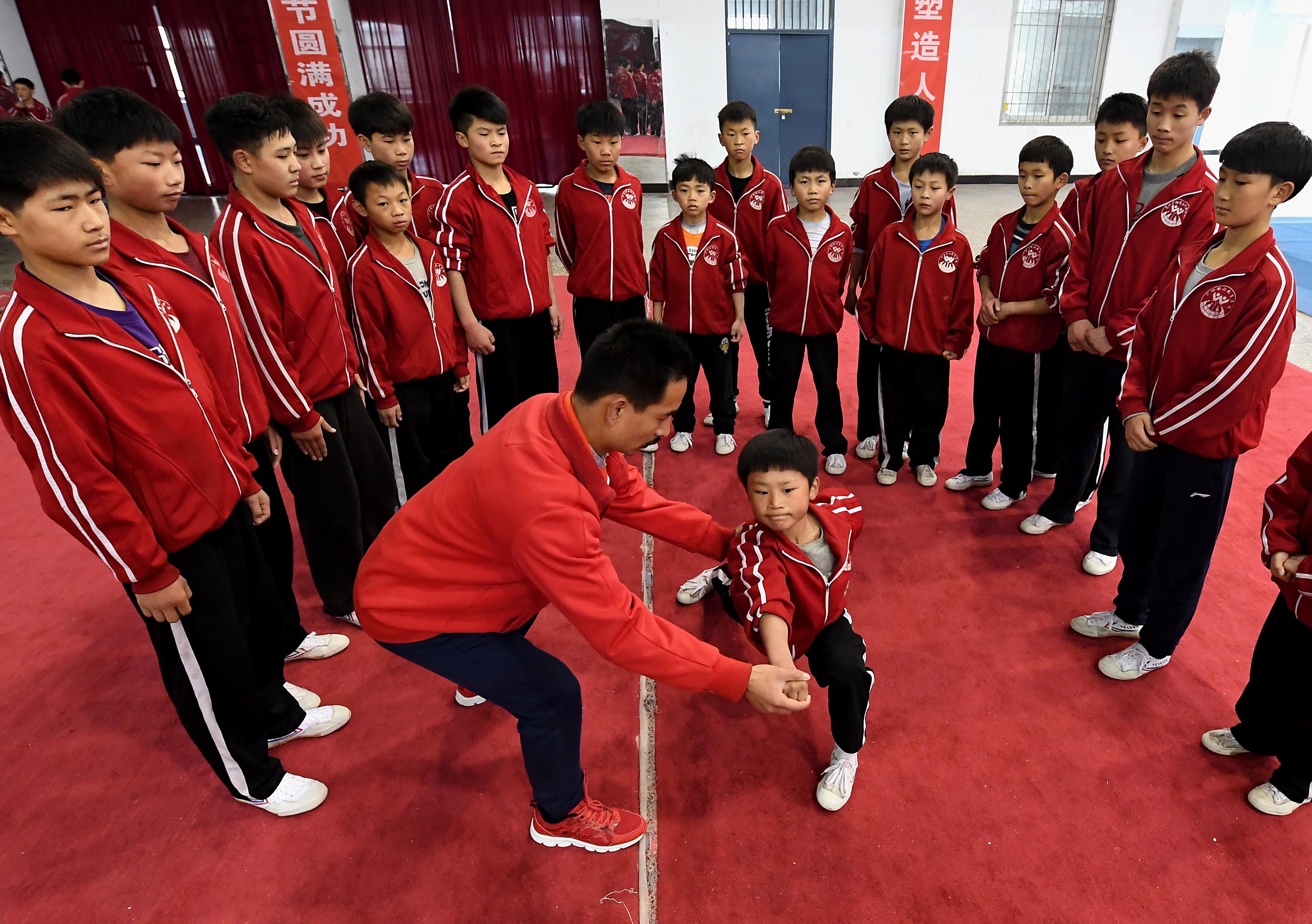 12月15日,少林塔沟武术学校的一名教练在练功房内教学员练功.