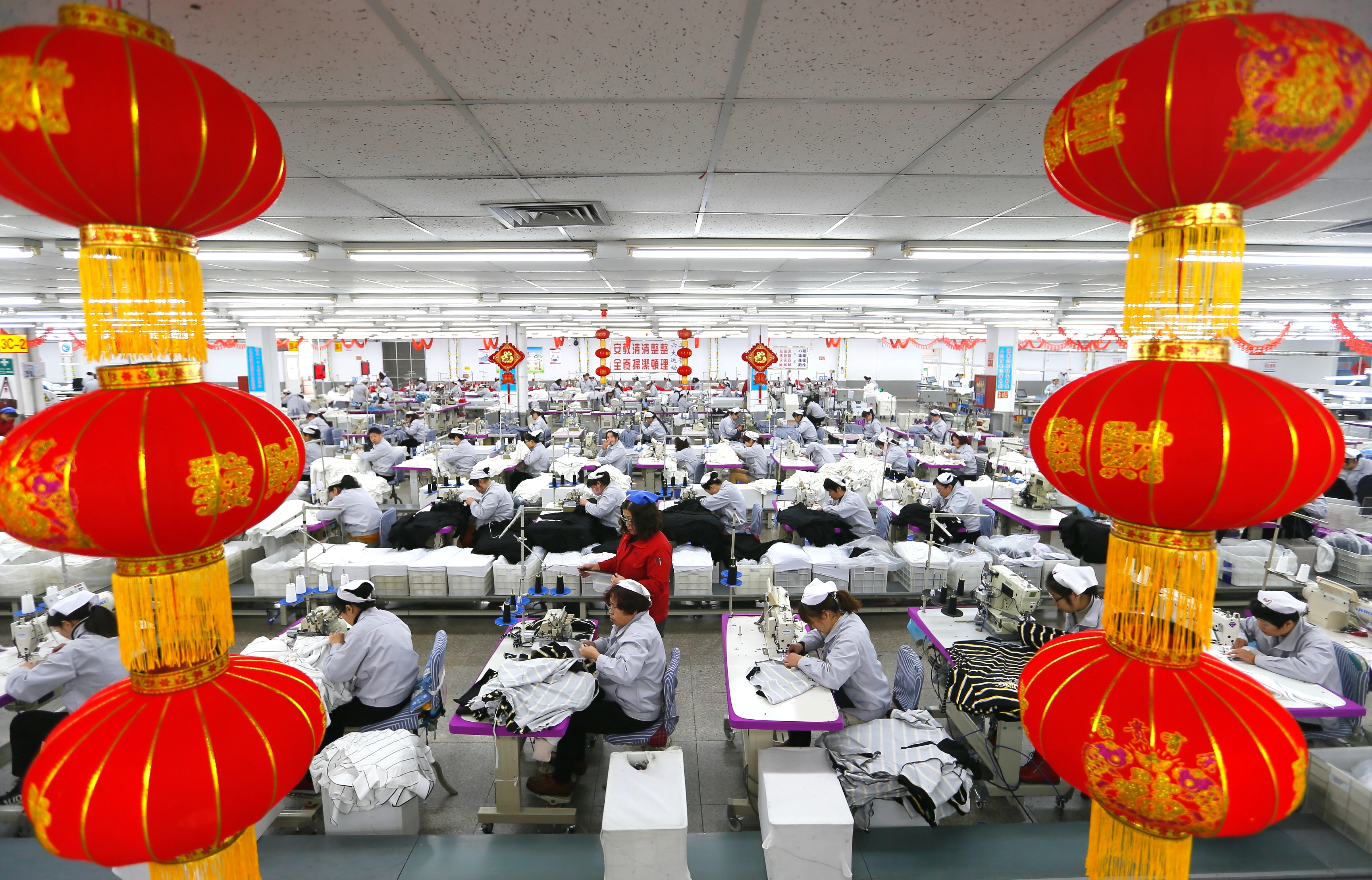 在山东省青岛市即墨区一家大型纺织企业,缝纫工人在生产出口服装