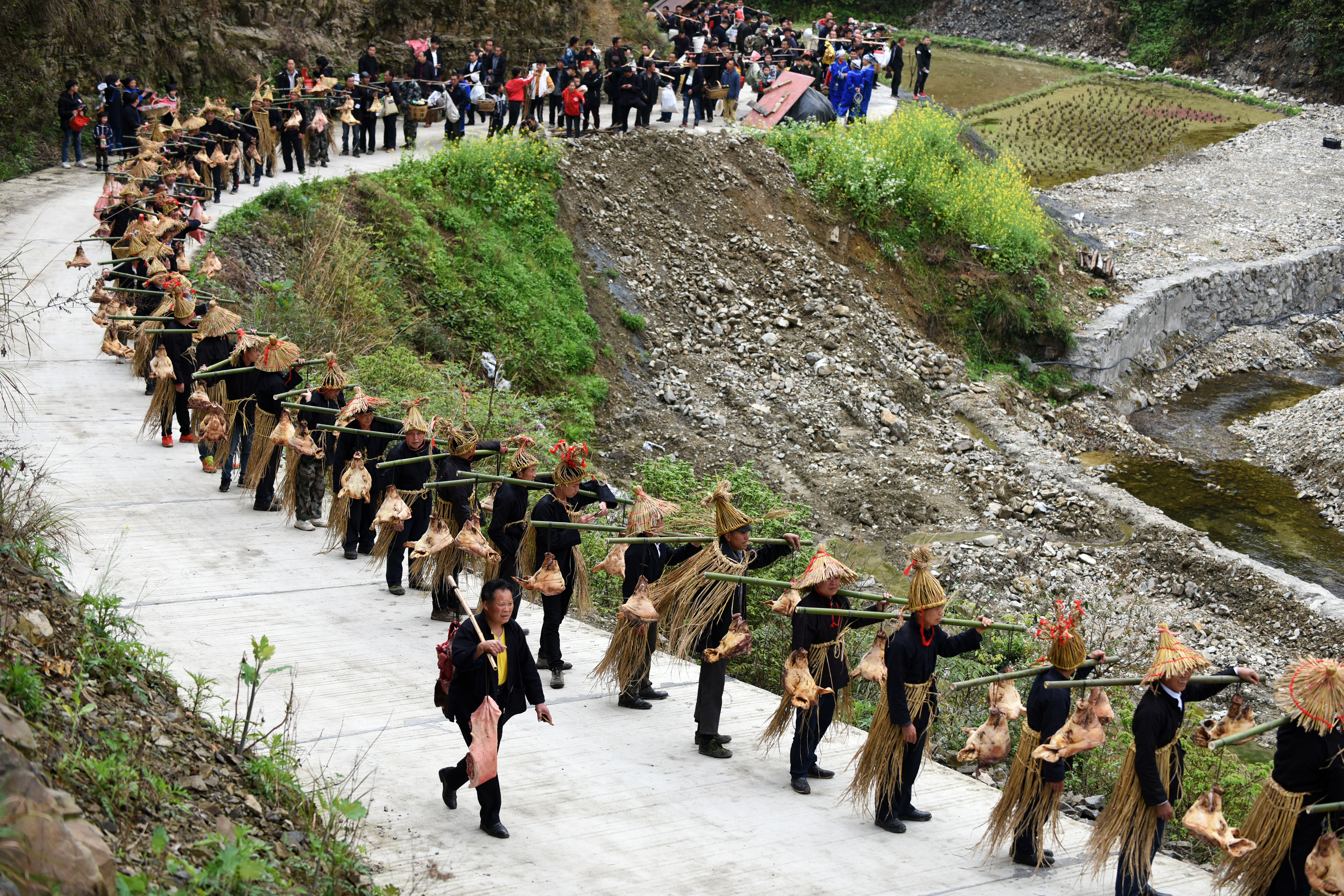 4月7日,苗族群众挑着祭品走在祭"巫耶"仪式途中.