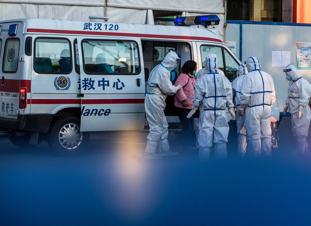 2月12日,医护人员将患者送入武汉体育中心方舱医院.