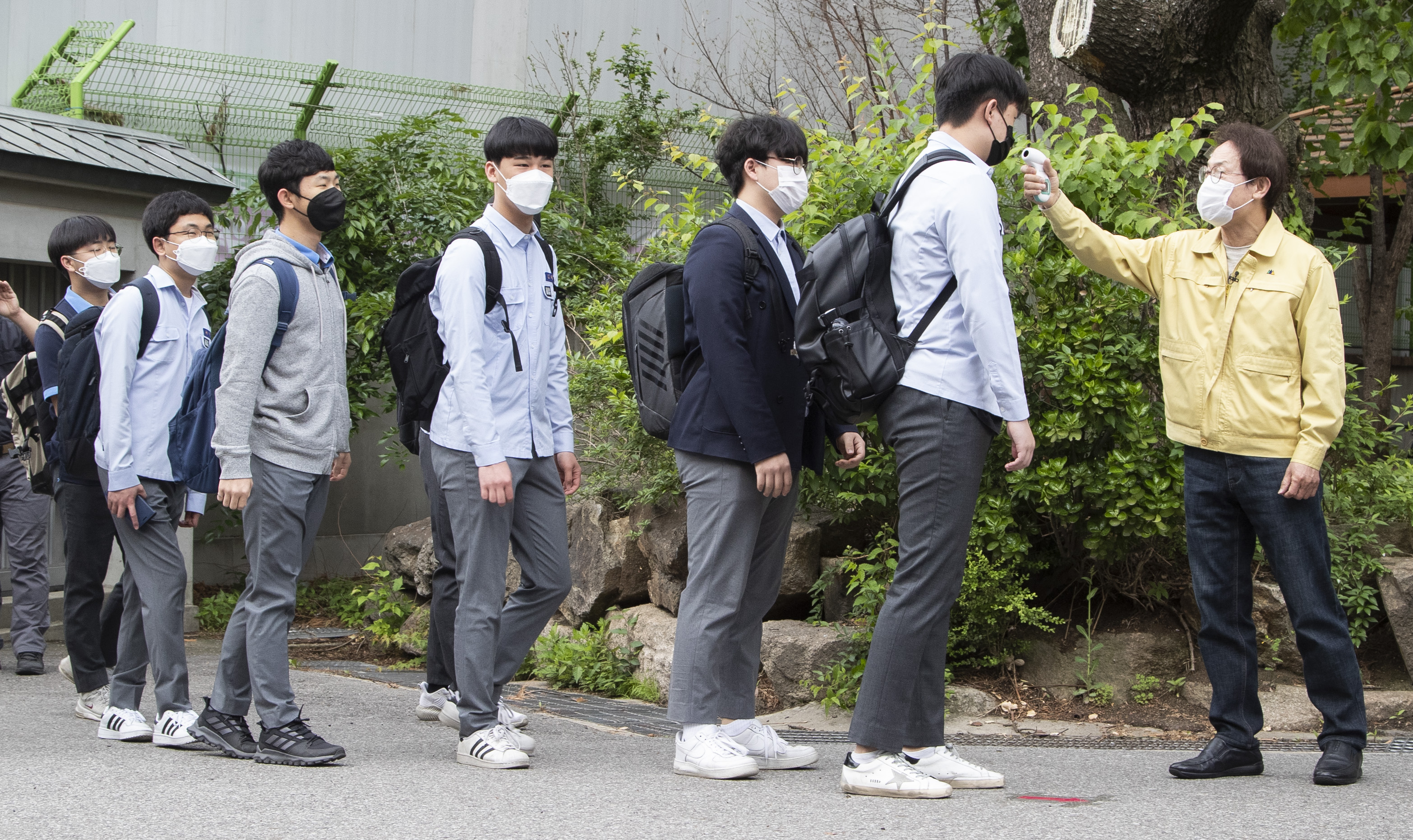 5月20日,韩国首尔景福高等学校的学生在入校前接受体温检测.