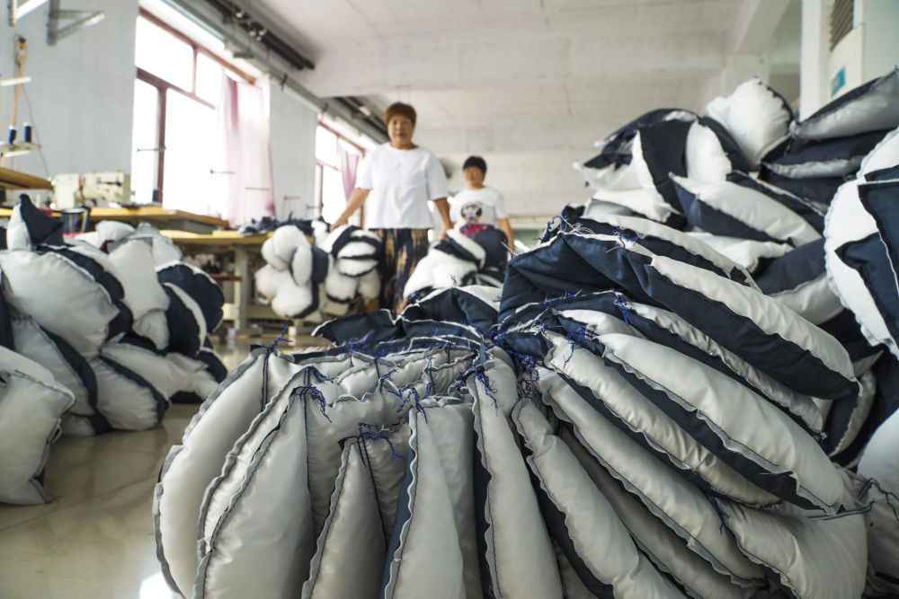 7月31日,女工们在河北省遵化市石门镇一家服装厂车间工作.