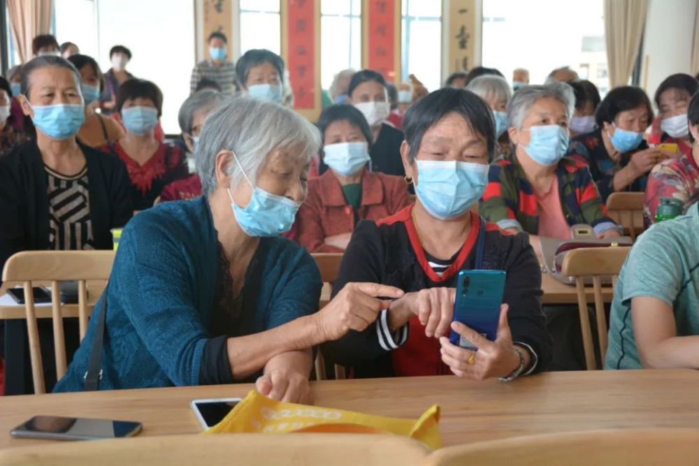 老年人在学习班上结对互助,共同学习智能手机的使用技巧.