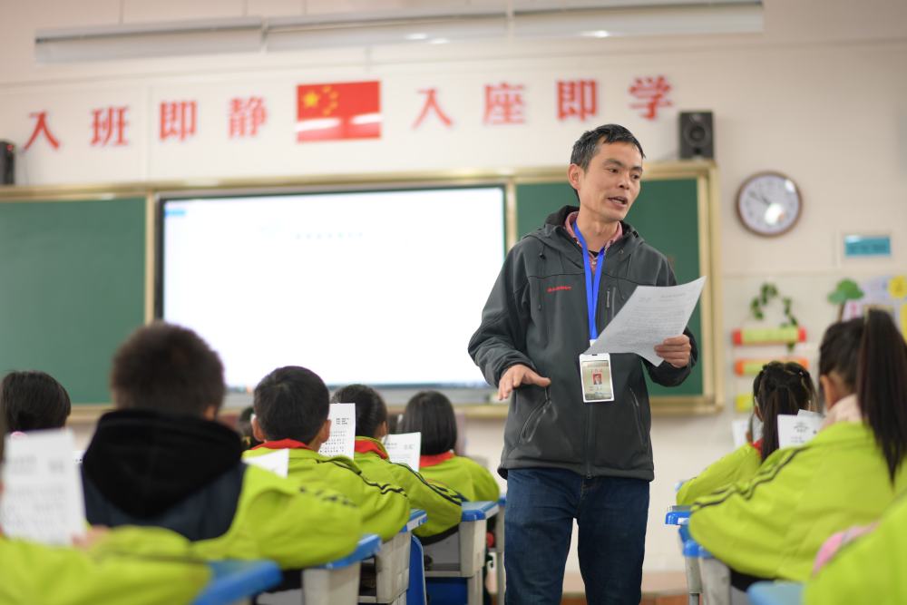 4月15日,杨明在贵州省毕节市黔西县锦绣学校给三年级学生上课.