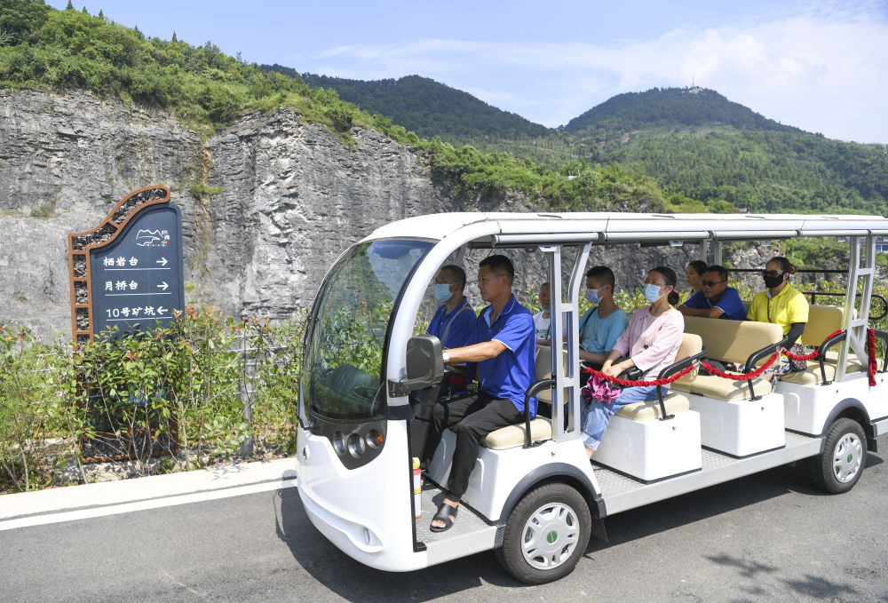 8月20日,重庆铜锣山矿山公园观光车司机余良明(左二)驾车带着游客