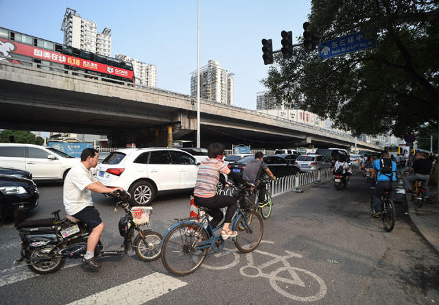 7月28日,骑行者在北京东三环中路辅路的自行车道骑行.