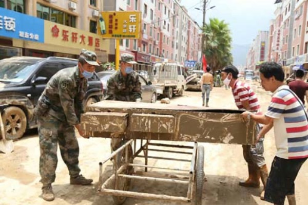 7月12日,第31集團軍某團官兵在福建省閩清縣坂東鎮幫助群眾清理街道