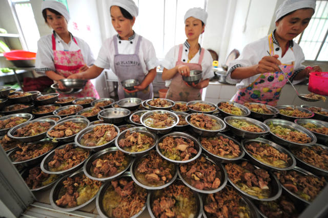 在广西都安瑶族自治县隆福乡渔洞小学,工人在食堂为学生准备营养午餐