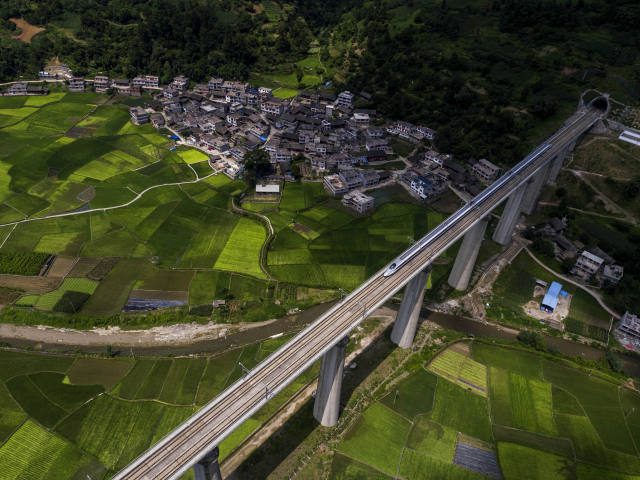 列车在沪昆高铁贵州省黔东南苗族侗族自治州境内的花桥村大桥上运行