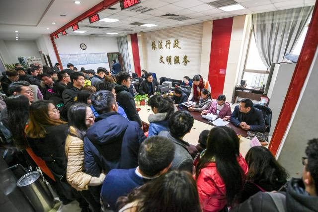 2月14日,新人们在河南省郑州市金水区民政局婚姻登记处排队登记介婚