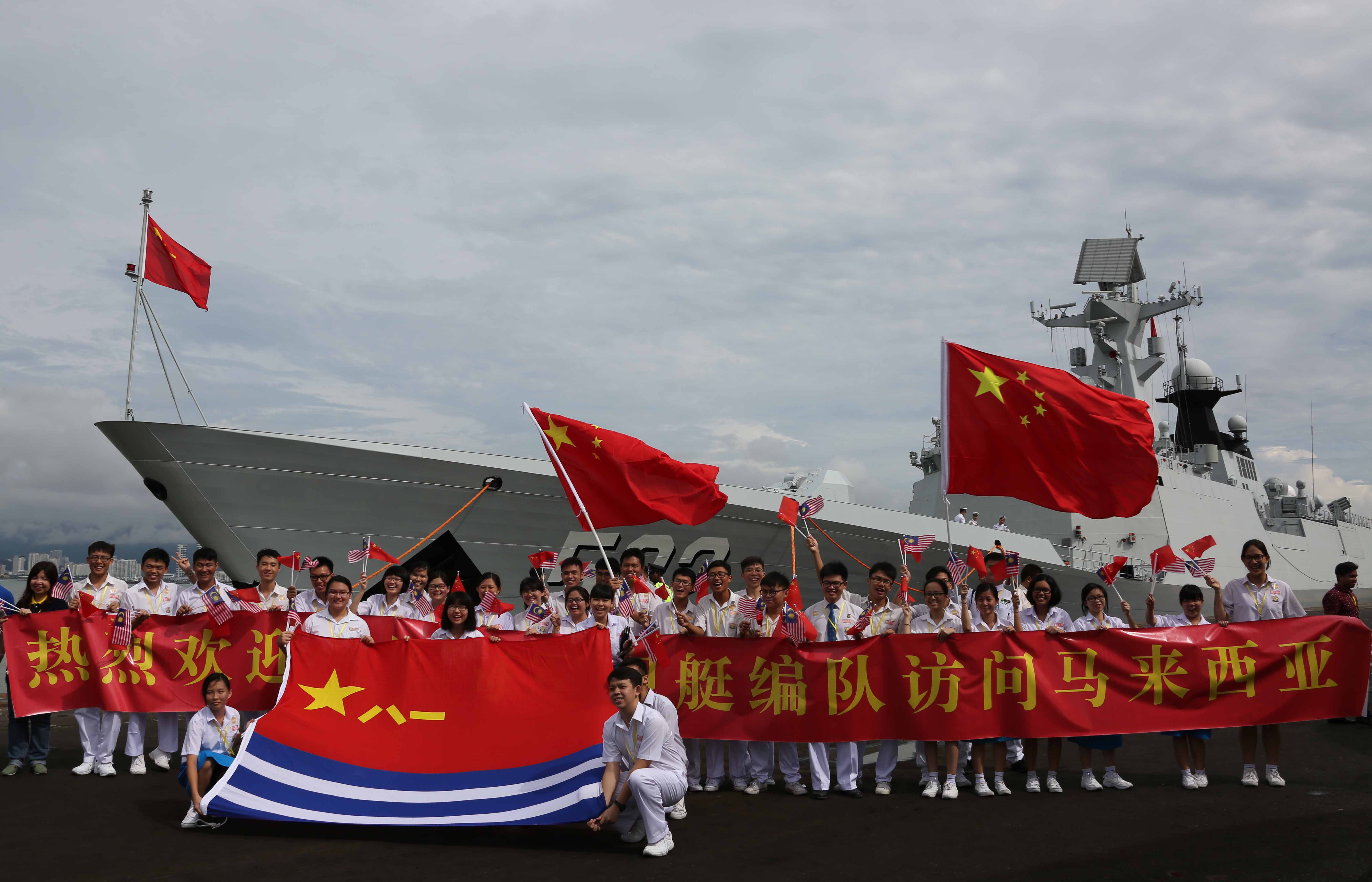 當地華人華僑學生們興高采烈地展開中國海軍軍旗