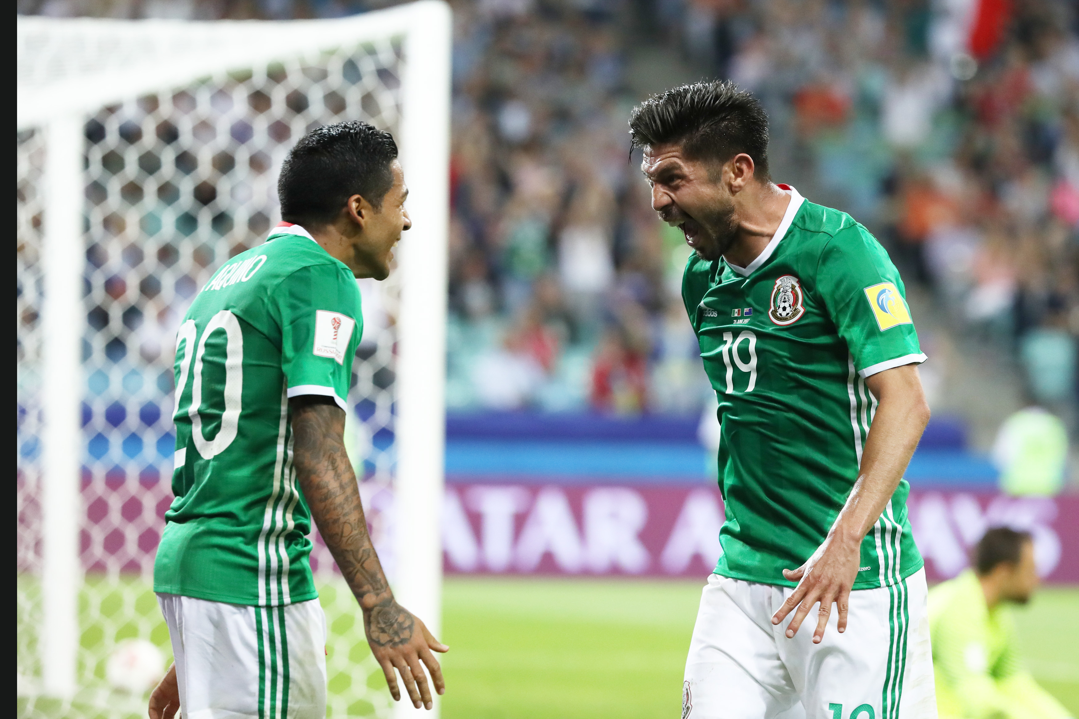 6月21日,墨西哥队球员佩拉尔塔(右)进球后与为其助攻的队友阿基诺庆祝