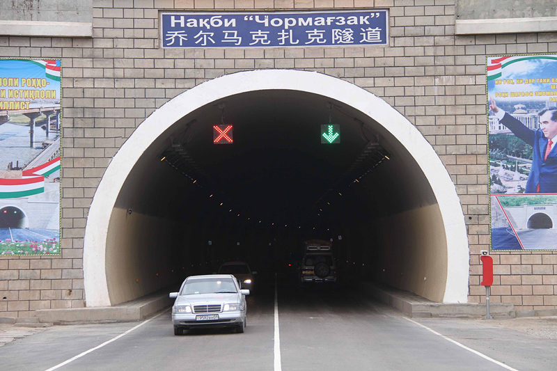 这是2013年11月6日，车辆从通往塔吉克斯坦首都杜尚别的塔中公路乔尔马克扎克隧道通过。在塔吉克斯坦交通“大动脉”上，随处都能看见中国路桥等企业留下的印记。新华社记者 沙达提 摄