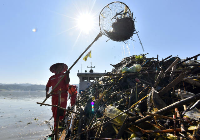 7月23日,崔金龙和朱国玉在清漂船上打捞水面漂浮物垃圾.