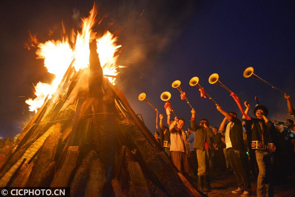 2014年7月26日,彝族同胞在火把節上點燃篝火,吹起嗩吶.