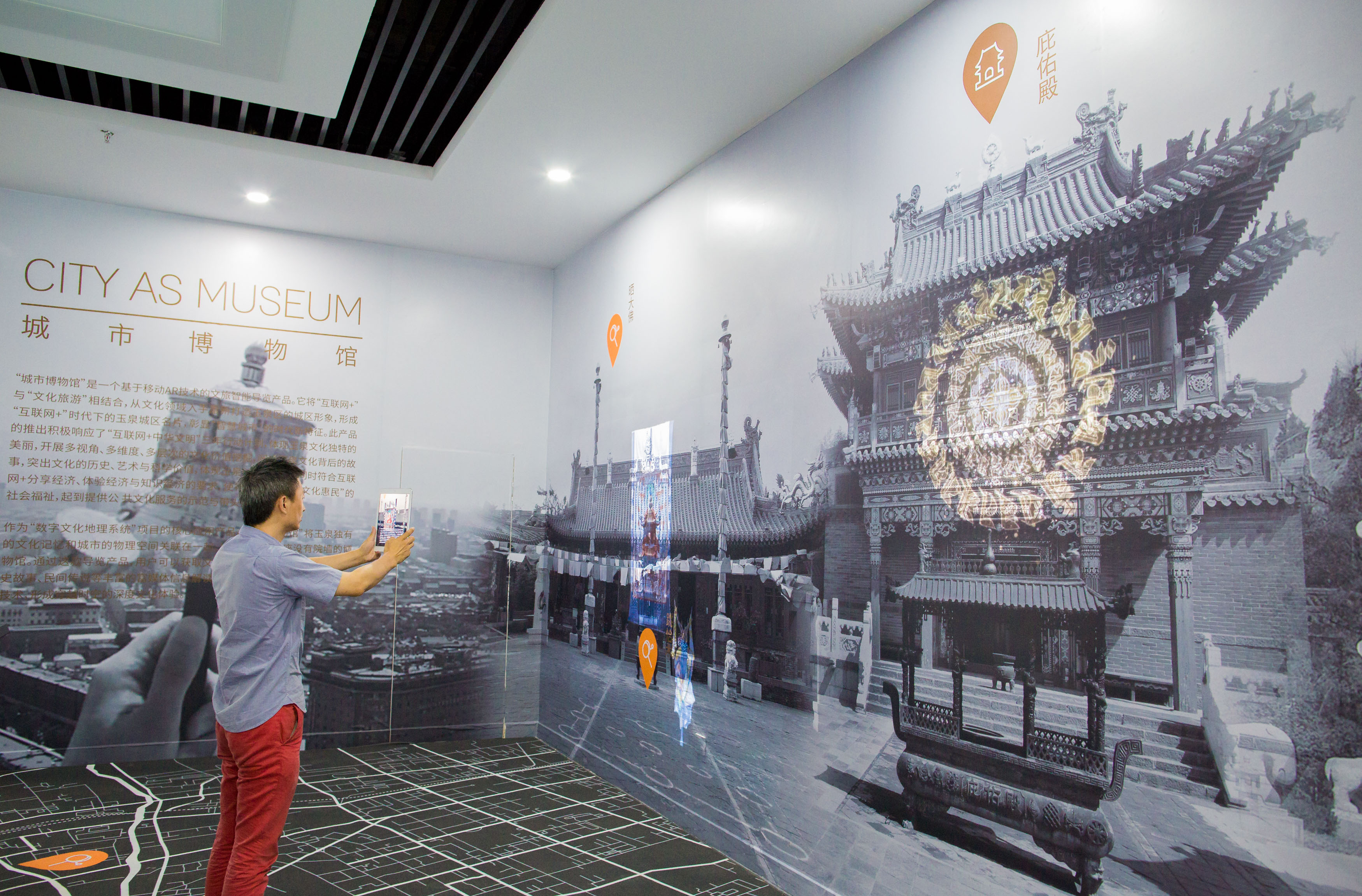 区大数据应用产业基地的工作人员通过平板设备展示城市博物馆ar体验墙