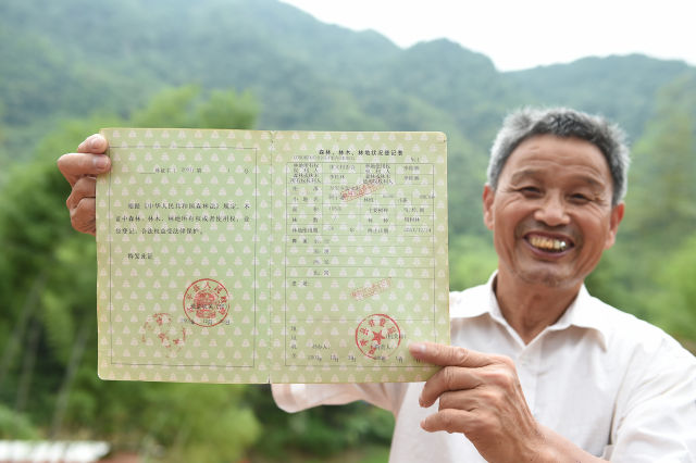 福建省武平县万安镇捷文村村民李桂林在展示林权改革后领到的林权证