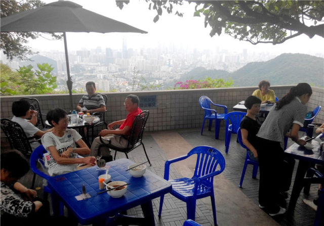 2015年5月1日，市民在广州白云山山顶的“望景餐厅”吃米粉、赏美景。新华社记者 卢汉欣 摄