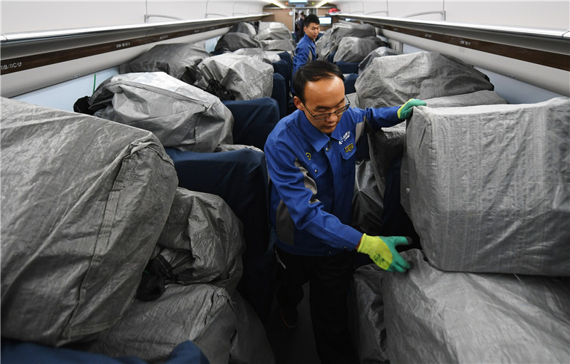 11月11日，工作人员在D2711次动车组列车上检查已经装车的快递包裹。新华社记者 陈斌 摄