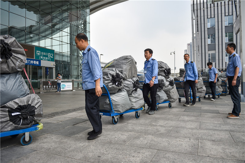 11月11日，深圳北站的工作人员将快递包裹运往站内。新华社记者毛思倩摄