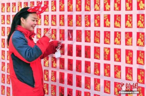资料图：2018年2月16日，大年初一，游客来到天津方特欢乐世界红包墙前抢包红。<a target='_blank' href='http://www.chinanews.com/'></p>中新社</a>记者 佟郁 摄