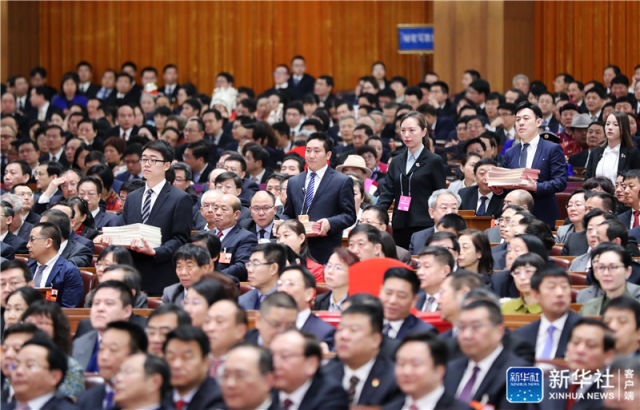3月17日，十三届全国人大一次会议在北京人民大会堂举行第五次全体会议。这是工作人员准备发放选票。新华社记者 刘卫兵 摄