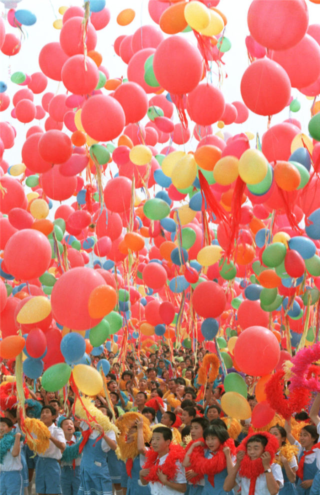 手持气球的少年儿童在北京参加国庆节庆祝活动(1984年10月1日摄).