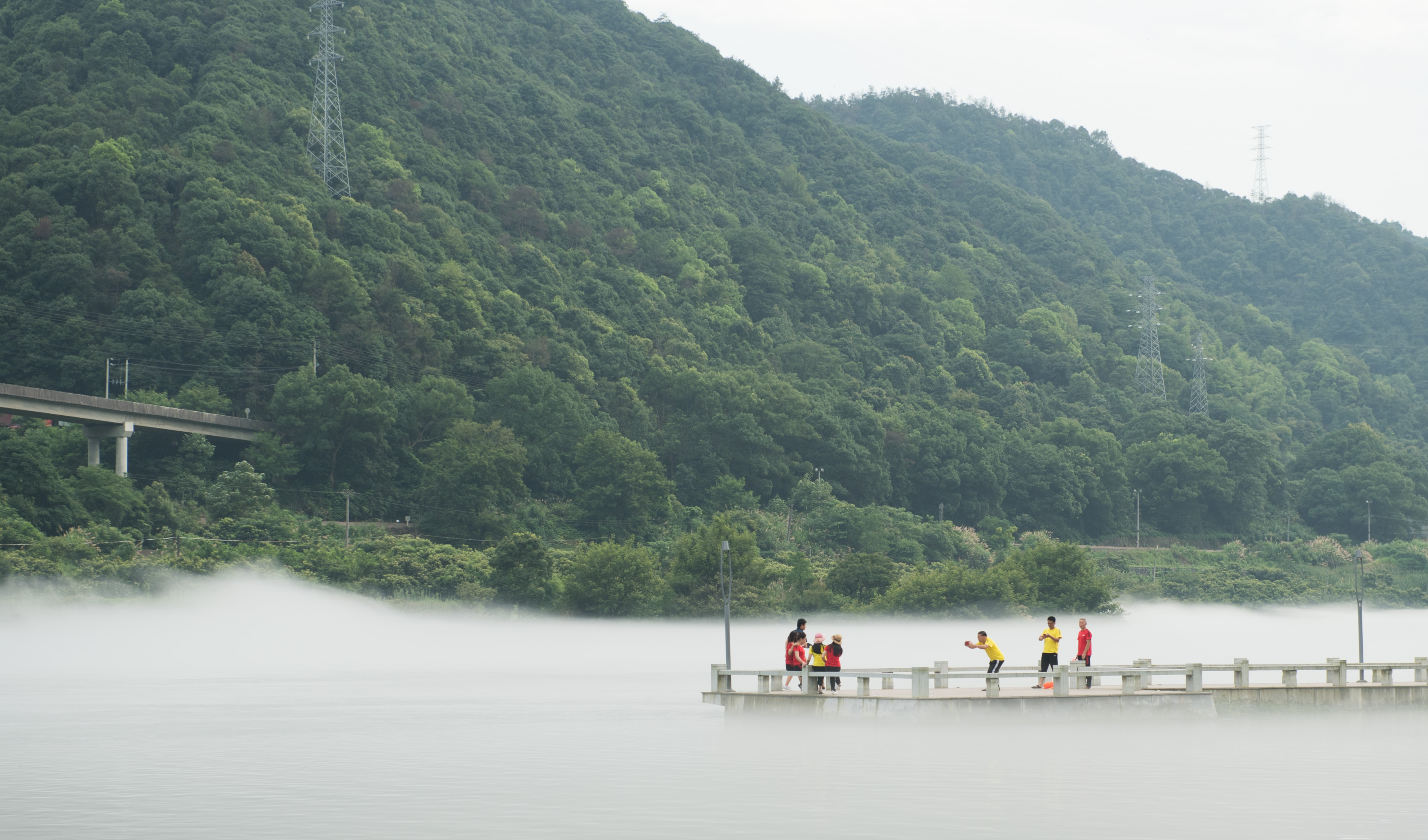 7月17日,遊客在新安江的霧氣中留影.