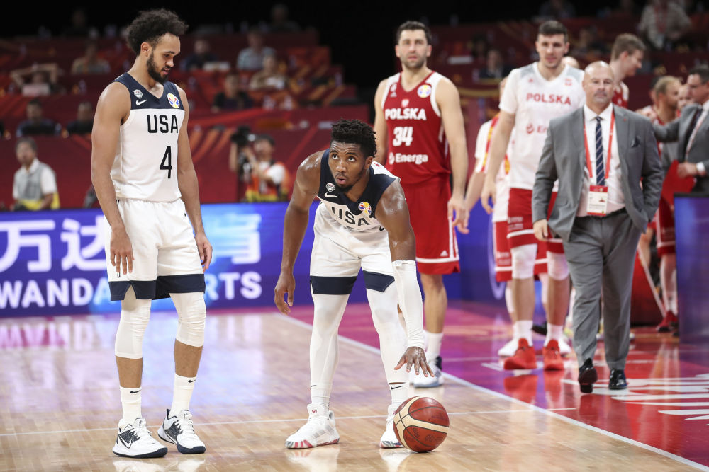 　　9月14日，美国队球员米切尔（左二）在比赛结束时将篮球放在场地上。新华社记者孟永民摄

