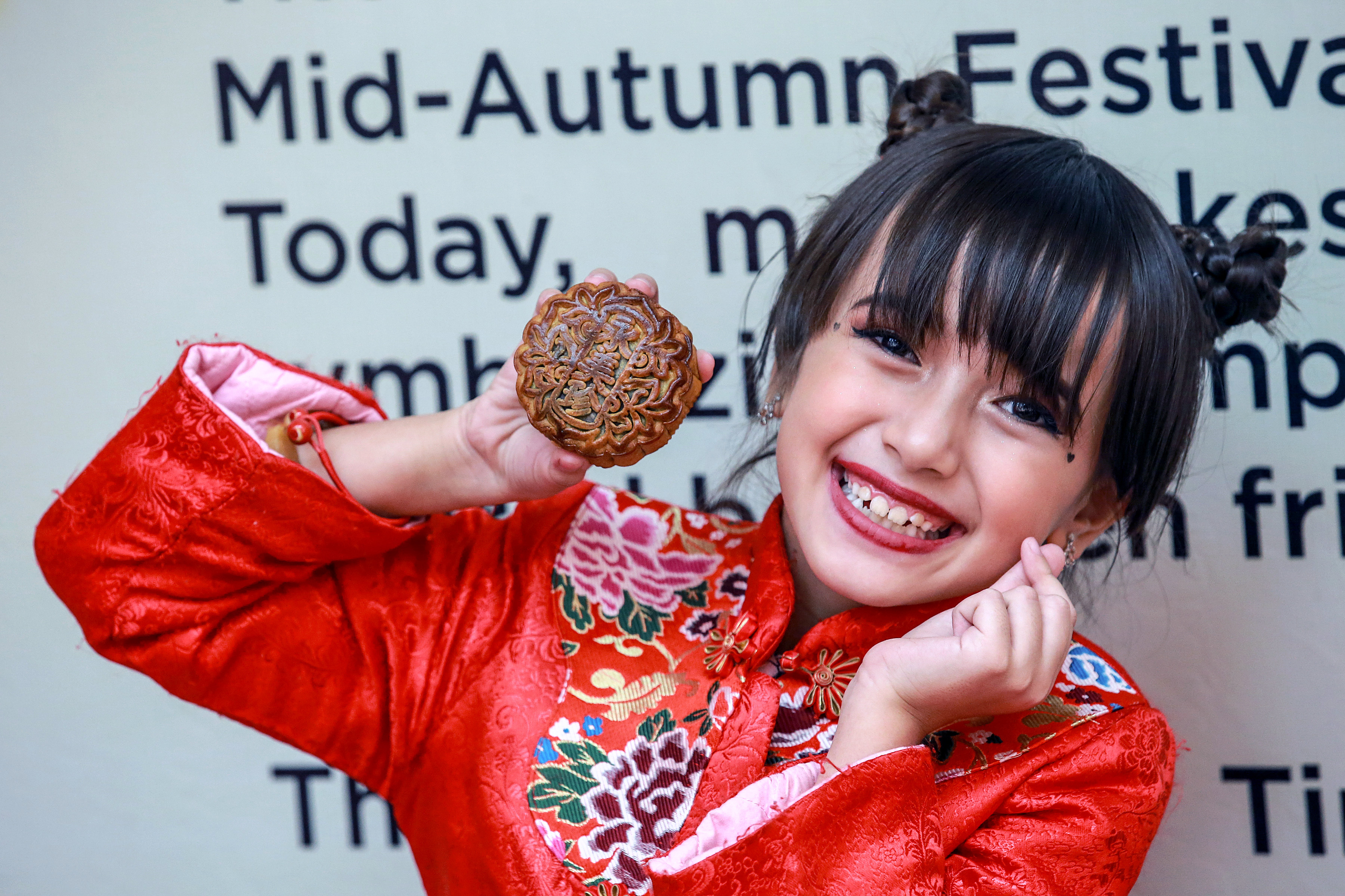 2019年9月11日,在菲律宾马尼拉唐人街,一名女孩手拿月饼拍照,迎接