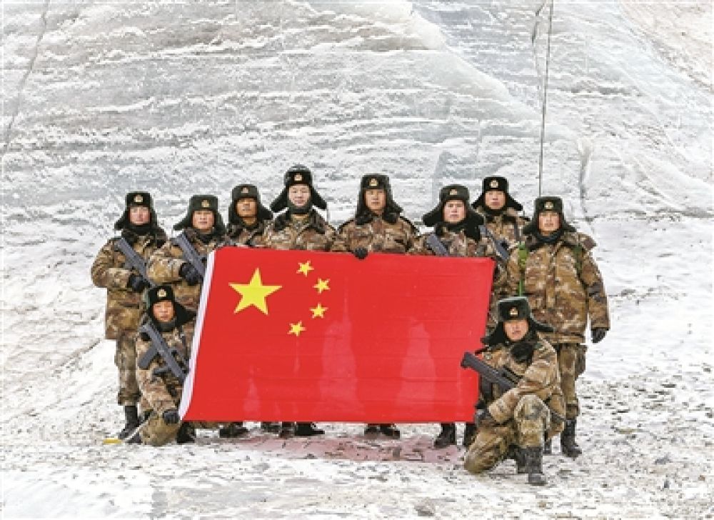 到达目的地后,官兵展开国旗向祖国和人民送上祝福.