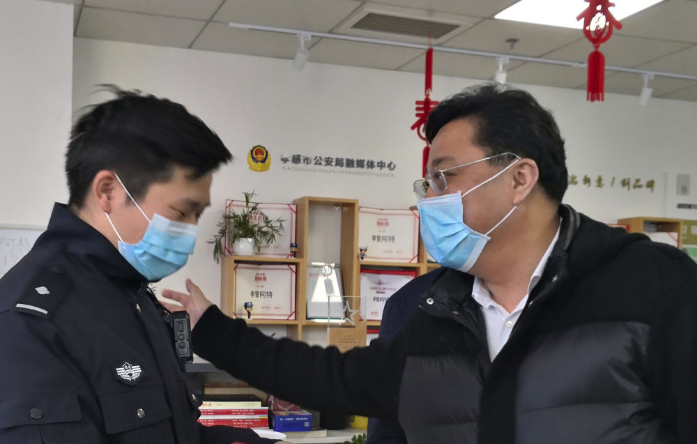 孝感市公安局民警陈特(左)在与领导交谈(2月21日摄).新华社发