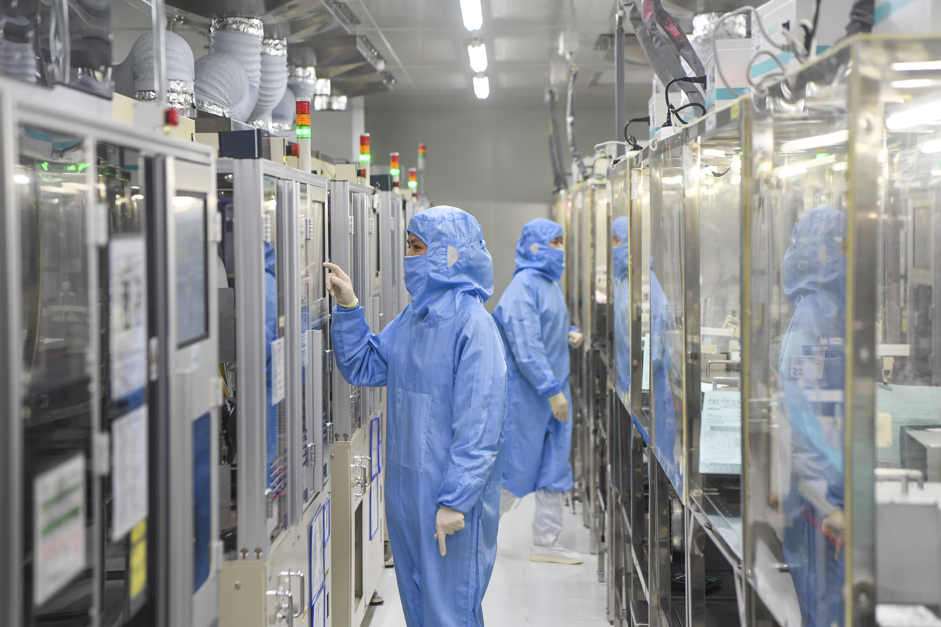 位于重庆高新区的台晶(重庆)电子有限公司工作人员在晶振封装无尘车间