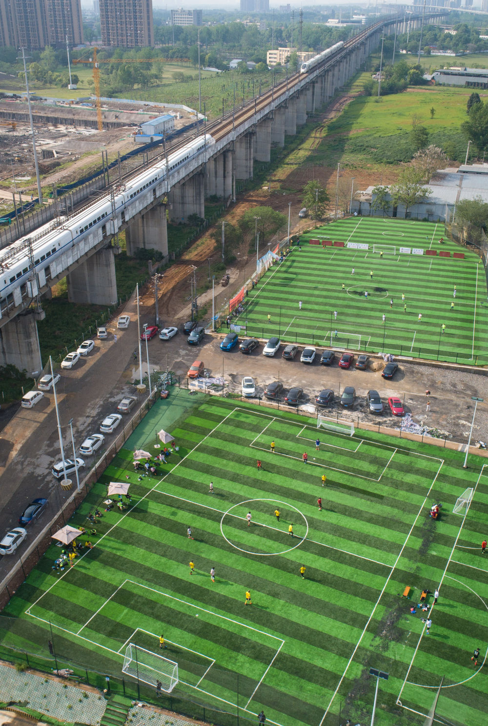 4月19日,足球爱好者在进入武汉百骏体育公园足球场前接受体温检测