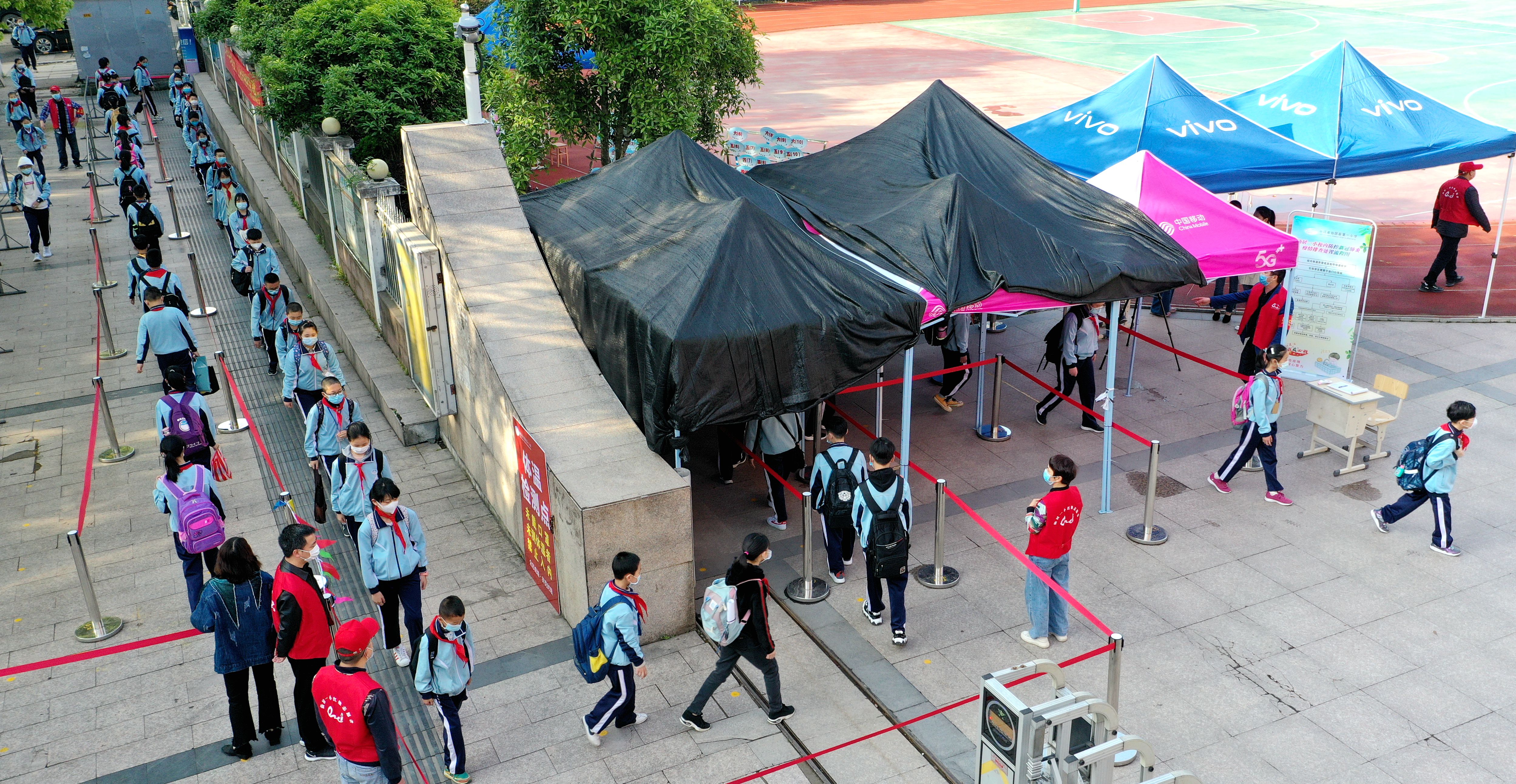 4月20日,在浙江省仙居县第一小学,复课的小学生有序进入校园.