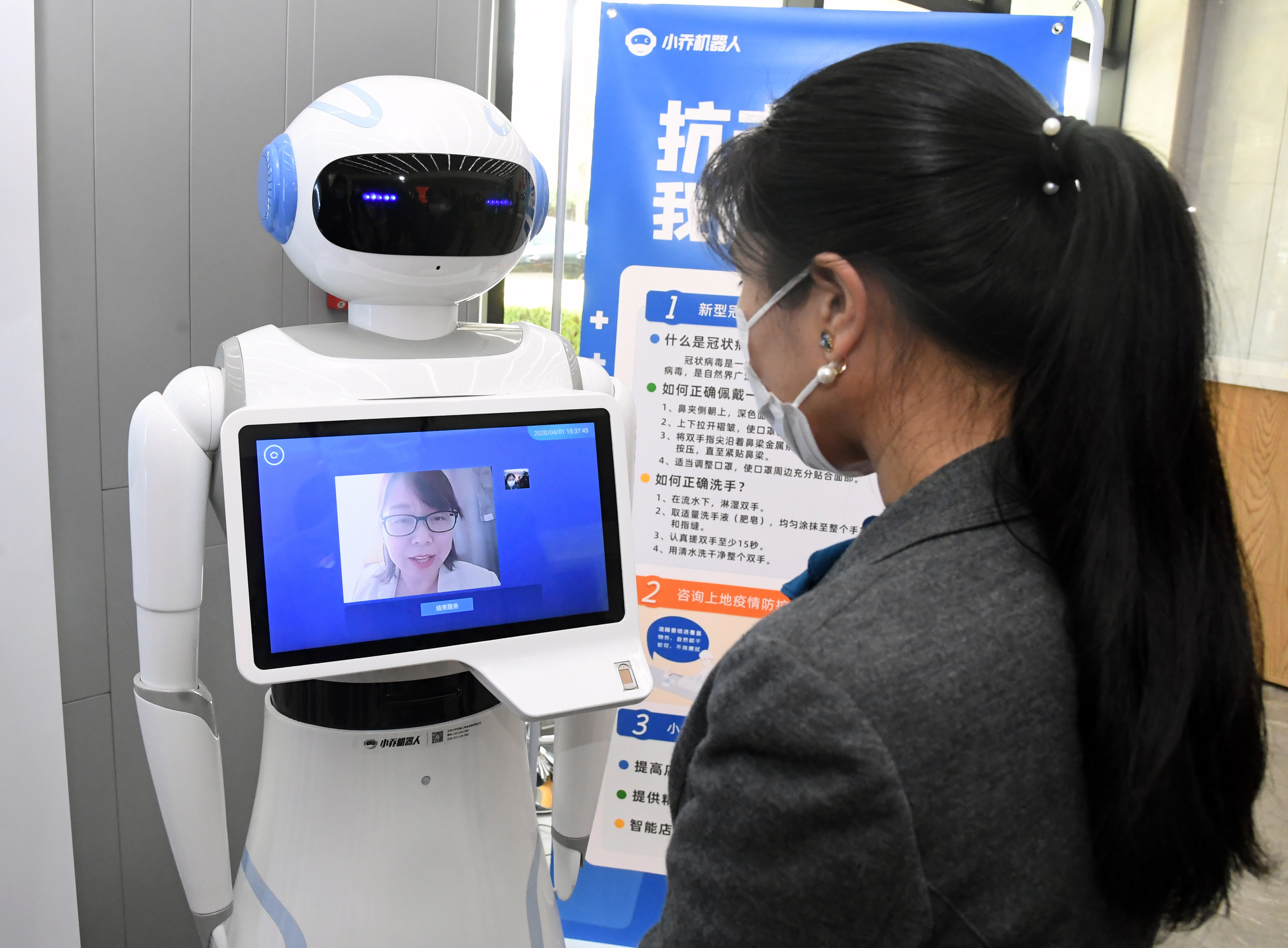 一座办公楼内,园区工作人员通过智能机器人与上地医院的医生视频交流