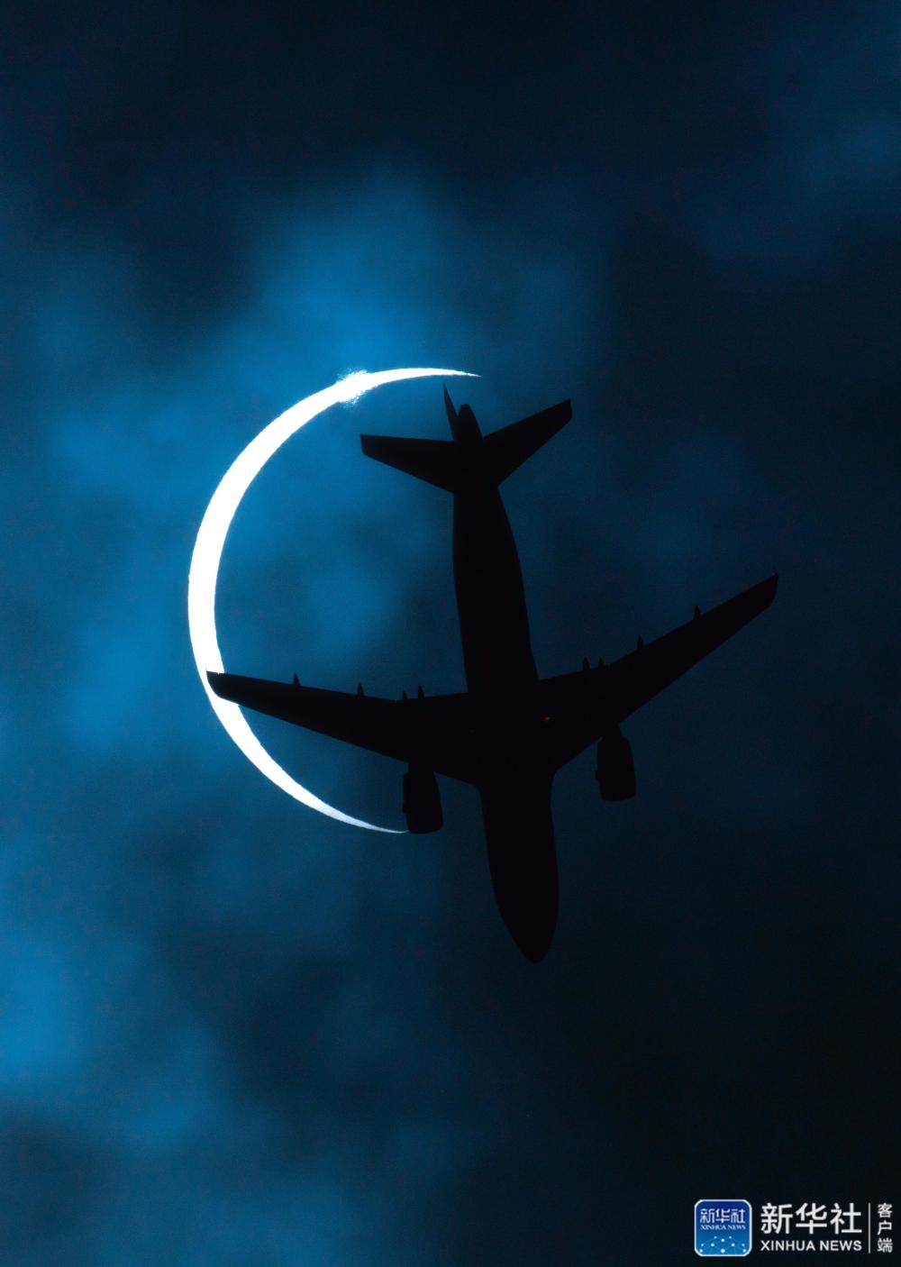 6月21日，拉萨上空一架飞机飞过发生日食的太阳。“日环食”天文景观于6月21日“夏至日”下午在天宇上演。新华社记者 普布扎西 摄