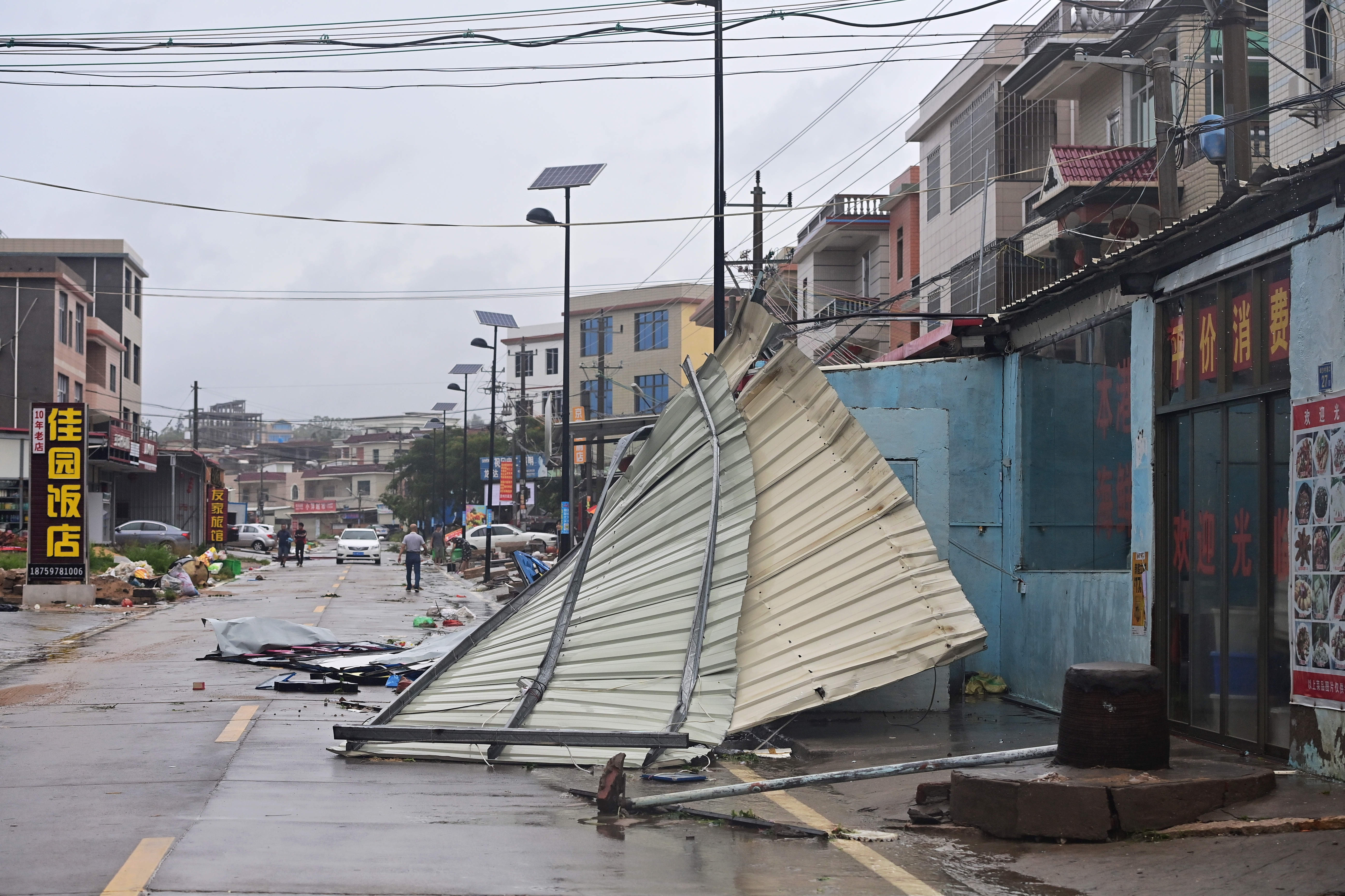 8月11日,在福建漳州漳浦县前亭镇,沿街商铺的广告牌被大风刮倒.
