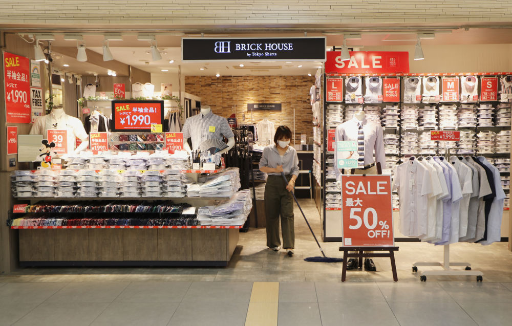 8月17日,一名佩戴口罩的店员在日本东京一家商店里清洁地面.