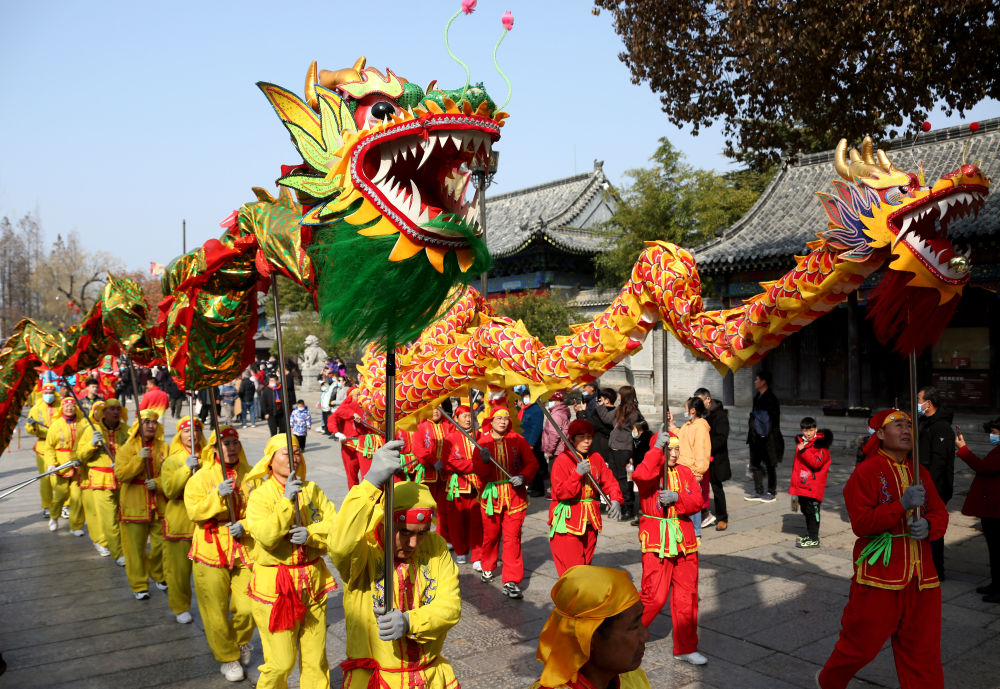 2月16日,游客在京杭大运河畔的山东省枣庄市台儿庄古城观看社火巡游