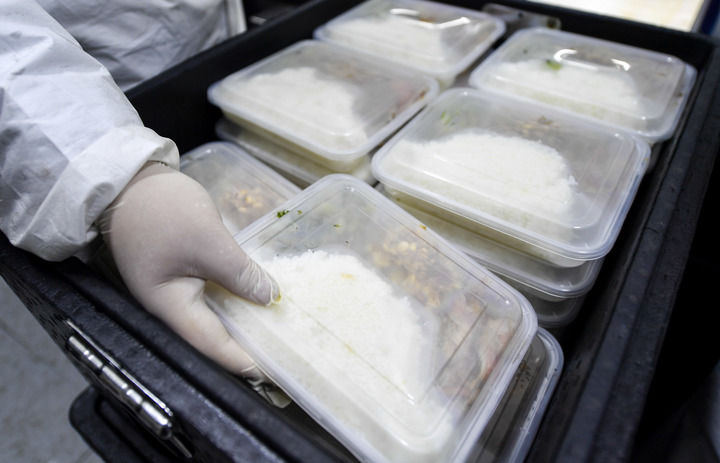 配送人员在车间外将完成打包后的盒饭装箱.