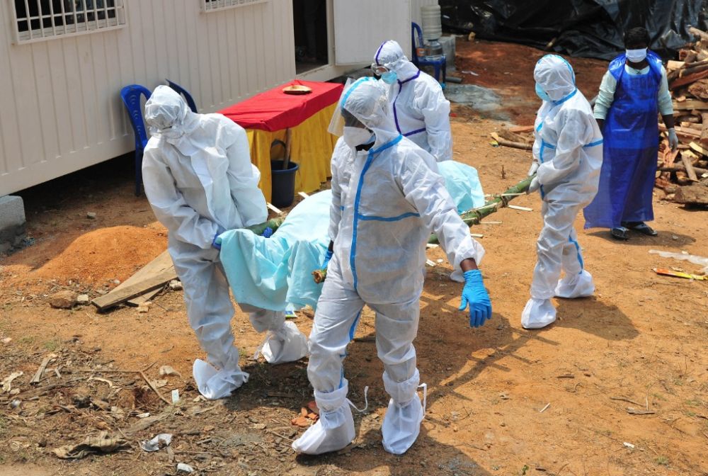 4月26日,工作人员在印度城市班加罗尔搬运新冠死者的遗体.
